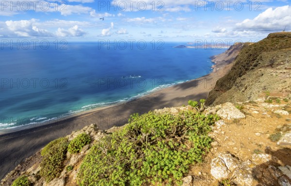 View from the Risco de Famara cliffs to the coast and the sea with the Famara beach, Playa de Famara, Lanzarote, Canary Islands, Spain