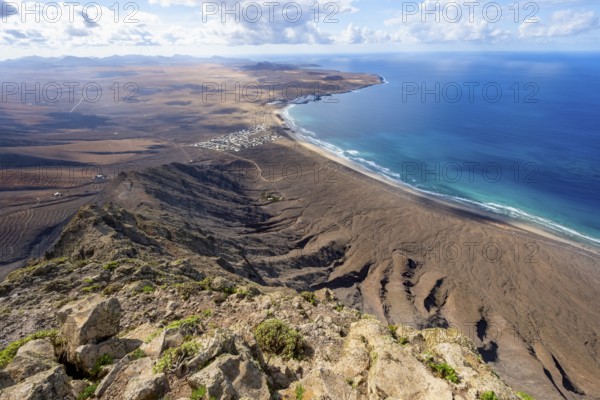 Castillejo viewpoint, view from the Risco de Famara cliffs to the coast and the sea with the Famara beach, Playa de Famara, Lanzarote, Canary Islands, Spain