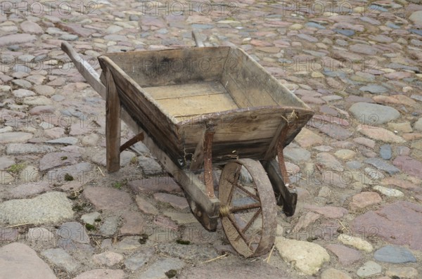 Old-fashioned wheelbarrow on paving stones in Den gamle by, The old village, open air museum in Odense, Fyn island, Fuen, Denmark, Scandinavia
