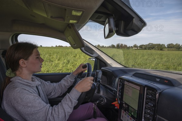 Young girl learns to drive a pickup truck on private property, Mecklenburg-Western Pomerania, Germany