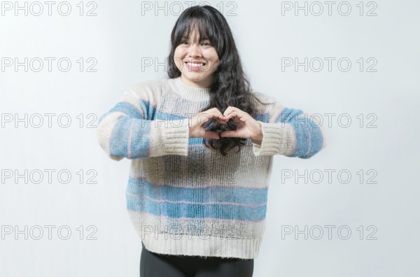 Beautiful asian girl making heart shape isolated. Happy asian woman making heart shape with hands