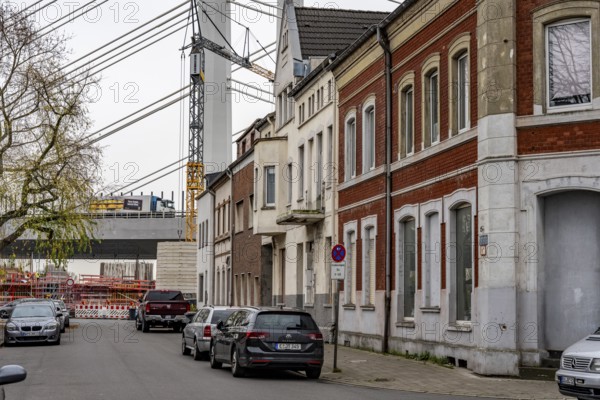 Residential buildings, directly on the A40 Neuenkamp bridge, in Duisburg-Homberg, pillars and cables of the new motorway bridge across the Rhine near Duisburg, construction phase of the 2nd bridge structure, North Rhine-Westphalia, Germany