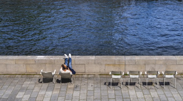 Promenade with chairs on the banks of the Spree from the Humboldt Forum, Berlin, Germany