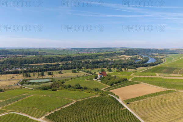 Pilgrimage church Maria im Weingarten, wide landscape view with vineyards, river and fields to the horizon under blue sky, aerial view, near Volkach am Main, Lower Franconia, Mainfranken, Bavaria, Germany