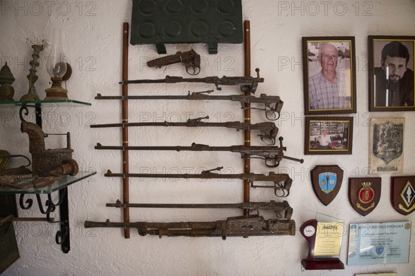 Wall-mounted antique rifles and honours with accompanying portraits, War Museum, Military Museum, Private Military Museum, Platanos, Leros, WW2, Dodecanese, Greek Islands, Greece