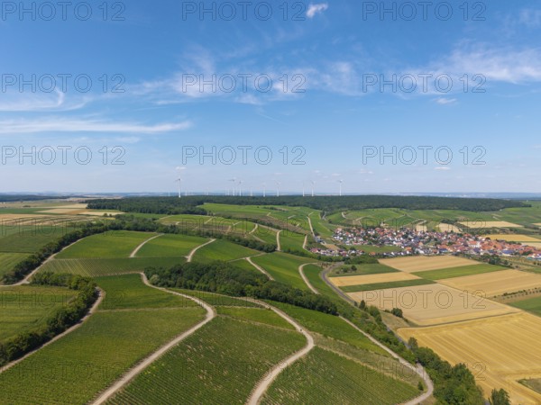 Panorama of vineyards stretching to a village with wind turbines on the horizon, Eisenheim near Volkach, aerial view, Mainfranken, Mainschleife, Franconia, Lower Franconia, Bavaria, Germany