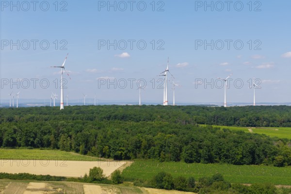 Several wind turbines on the horizon above a forest and fields, under a blue sky, near Volkach, aerial view, Mainfranken, Mainschleife, Franconia, Lower Franconia, Bavaria, Germany