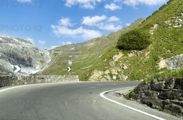 View of the hairpin bend in front with signpost 16th hairpin bend Tornante 2320 metres narrow, hidden bend from the eastern ramp Ascent to the descent from the Stelvio Stelvio Alpine Pass mountain road above the tree line, with many hairpin bends in the background leading to the pass summit of 2757 2758 metres high pass road mountain pass Stelvio Stelvio Pass, Stelvio, South Tyrol, Alto Adige, Italy