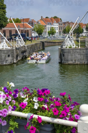 Middelburg, Zeeland, Netherlands - Town houses on the inner harbour in the old town. Tourists take a boat across the canals through the old town centre during a city tour