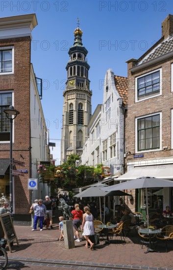 Middelburg, Zeeland, Netherlands - Korte Delft pedestrian area on the corner of Reigerstraat. The small, constantly decorated alleyway, here called Vogelbauer, in the old town centre is one of the city's sights. There are many cafés and shops in the neighbourhood. At the back is the Tall John Abbey Tower, a restored church tower from the 14th century with 207 stone steps leading to a viewing gallery