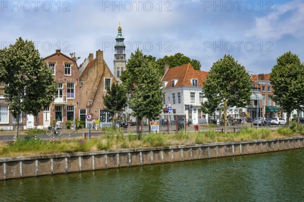 Middelburg, Zeeland, Netherlands - Townhouses on the Turfkaai at the Binnenhaven in the historic city centre. At the back is the Tall John Abbey Tower, a restored church tower from the 14th century with 207 stone steps leading to a viewing gallery