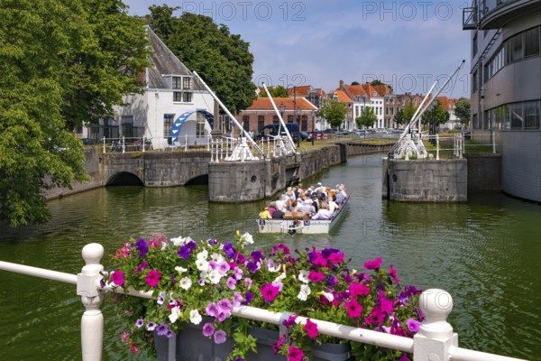 Middelburg, Zeeland, Netherlands - Town houses on the inner harbour in the old town. Tourists take a boat across the canals through the old town centre during a city tour