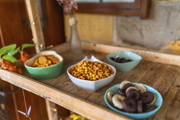 Colorful candy and snacks served on a wooden tray during a wedding celebration, adding a touch of sweetness and delight to the festive atmosphere