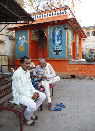 Indian men in white clothes at a colourful temple in the old town, Bundi, Rajasthan, India