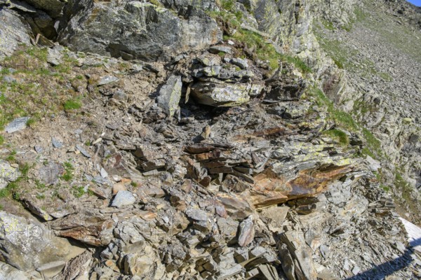 Small pieces of rock eroded rock lying open on mountainside of rocky peak in Alps, Italy