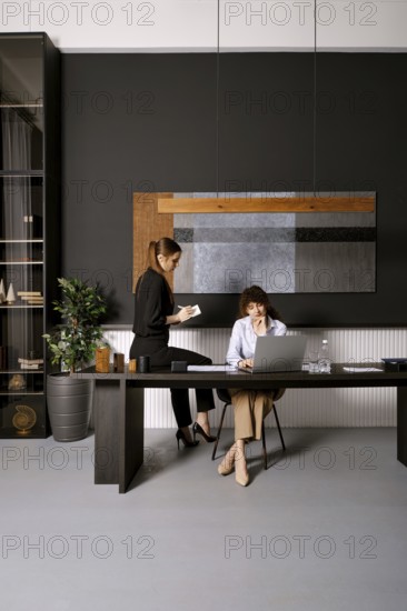 Women collaborating in a modern office space while discussing project ideas during daylight hours