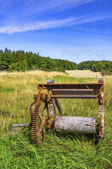 Traditional historical and rusty weathered agricultural equipment in a rural setting near Sunnersberg near Lidköping, Västergötland, Västra Götalands län, Sweden