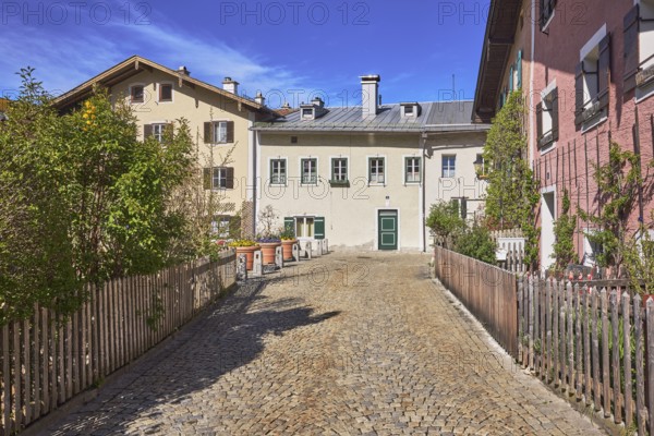 Old town, historic houses, street, cobblestones, facade, windows, doors, bushes, blue sky, cirrostratus clouds, Florianiplatz, Bad Reichenhall, district Berchtesgadener Land, Bavaria, Germany