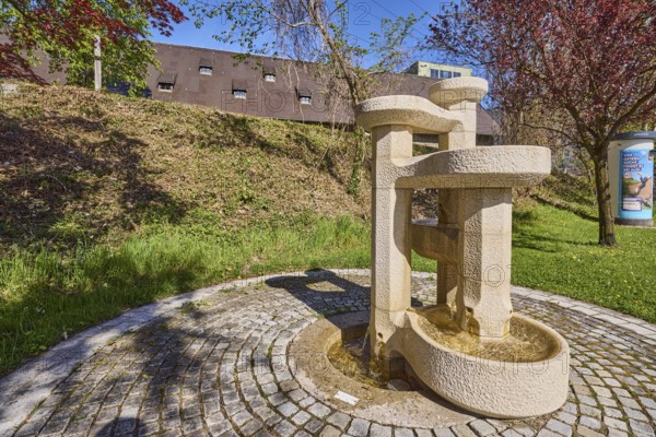 Stone fountain, fountain, cobblestones, trees, meadow, blue sky, cloudless, Anton-Winkler-Straße, Bad Reichenhall, district Berchtesgadener Land, Bavaria, Germany