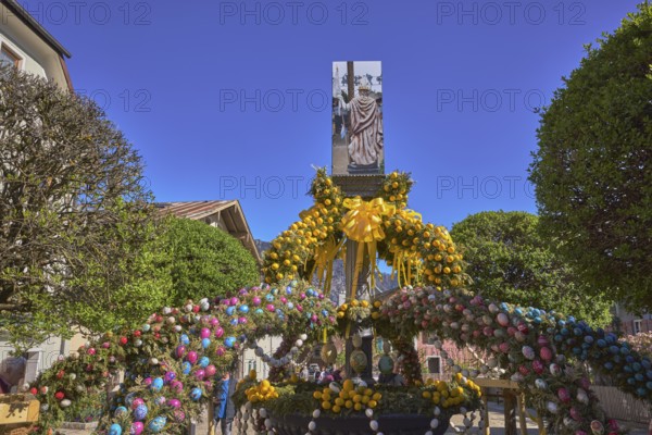 Easter fountain, Easter decoration, blown out coloured Easter eggs, trees, historical buildings, blue sky, cloudless, Florianiplatz, Bad Reichenhall, district Berchtesgadener Land, Bavaria, Germany