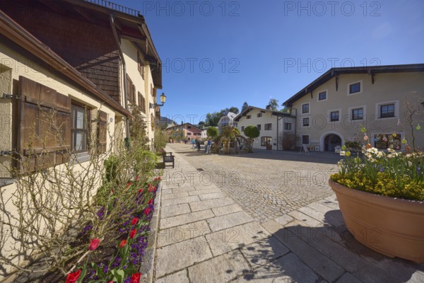 Historic buildings, houses, facade, window, window shutter, flower bed, square, paving stones, sandstone slabs, flower bucket, Easter decoration, blown out coloured Easter eggs, blue sky, cloudless, Florianiplatz, Bad Reichenhall, district Berchtesgadener Land, Bavaria, Germany