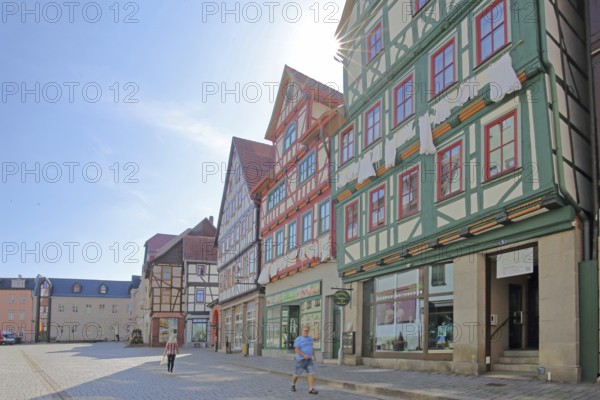 Red, green and brown half-timbered houses against the light, pedestrians, colourful, idyll, Auer Gasse, Schmalkalden, Franconia, Thuringia, Germany