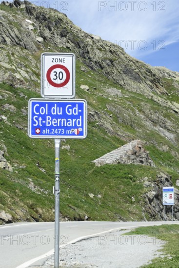 Traffic sign zone 30 at the border crossing from Italy to Switzerland at the Alpine pass Grenzpass Großer Sankt St. Bernhard Pass, below sign with inscription Col du Gd-St-Bernard and altitude alt. 2473 mt, Valais, Switzerland