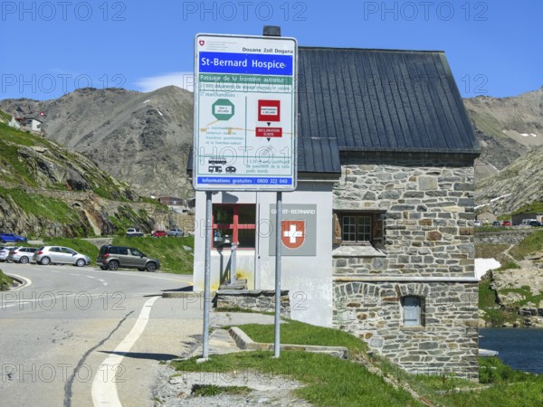 View of front sign with information for customs clearance at historic Swiss border building Border station Checkpoint for passport control Identity check Customs at border pass Road crossing National border State border Italy and Switzerland on the shore of Lac du Grand St-Bernard, Great Saint Bernard Pass, Colle del Gran San Bernardo, Col du Grand Saint Bernard, Valais, Switzerland