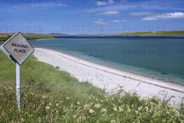Coastal road with a warning sign, situated on a white sandy beach, Hoy, Orkney Islands, Scotland, United Kingdom