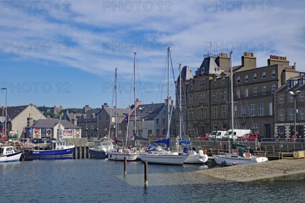 Coastal harbour with sailing boats and historic buildings under a bright blue sky, Kirkwall, Orkney Islands, Scotland, Great Britain