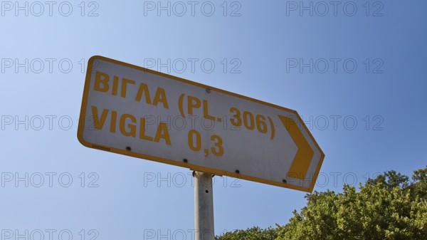 Directional sign in Greek and English under blue sky, Italian air defence position, ground defence position, PL306 with 6 cannons, WW2, Vigla Mountain, Vigla, above Lakki, Lakki, Leros, Dodecanese, Girech Islands, Greece