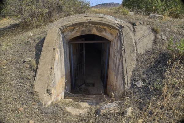 Dilapidated bunker entrance in nature, leading into the darkness, Italian air defence position, ground defence position, PL306 with 6 cannons, WW2, Vigla Mountain, Vigla, above Lakki, Lakki, Leros, Dodecanese, Girech Islands, Greece