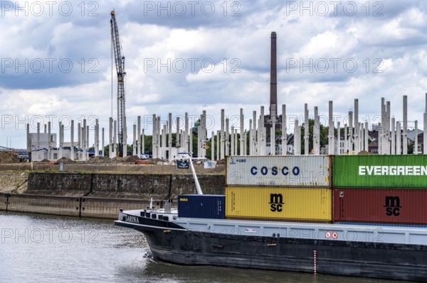 Construction of a new logistics hall on the Mercatroinsel, Hall 2, next to an existing hall, approx. 25, 000 square metres in size, in Duisburg-Ruhrort, shell construction, container freighter leaving the port canal for the Rhine, North Rhine-Westphalia, Germany