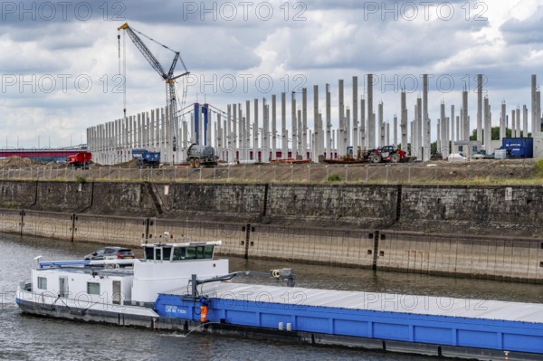 Construction of a new logistics hall on the Mercatroinsel, Hall 2, next to an existing hall, approx. 25, 000 square metres in size, in Duisburg-Ruhrort, shell construction, freighter enters the harbour canal, North Rhine-Westphalia, Germany