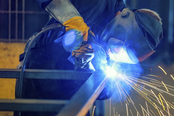 Germany - Theme photo metal industry. An industrial welder welds a workpiece