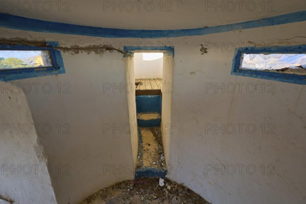 View from a worn round room with blue window frames into a dirty corridor, Lost Place, Lago anti-aircraft battery, bunker, Apitiki Mountain, Leros, Dodecanese, Greek Islands, Greece