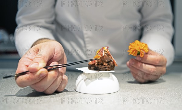 Castilian male hands create a dessert of dark chocolate and Iberico ham, Iberico ham factory in Villares de la Reina, province of Salamanca, Castile and Leon, Spain
