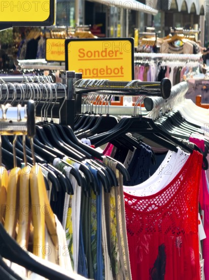 Summer dresses in bright colours on a clothes rack in a street sale in Wuppertal, Germany