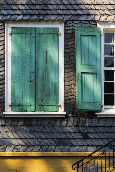 Weathered green shutters on a slate-clad house in Wuppertal, Germany