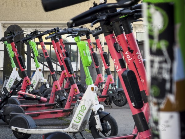 Many rental e-scooters parked on a pavement in Wuppertal, Germany