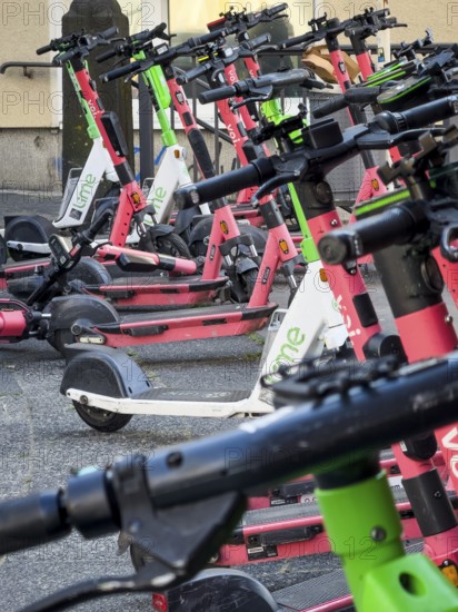 Many rental e-scooters parked on a pavement in Wuppertal, Germany