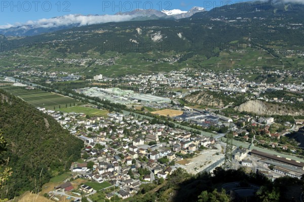 The towns of Chippis, foreground, and Sierre, background, in the Rhone Valley, the production facilities of the aluminium company Novelis Switzerland SA in the centre of the picture, Sierre, Valais, Switzerland