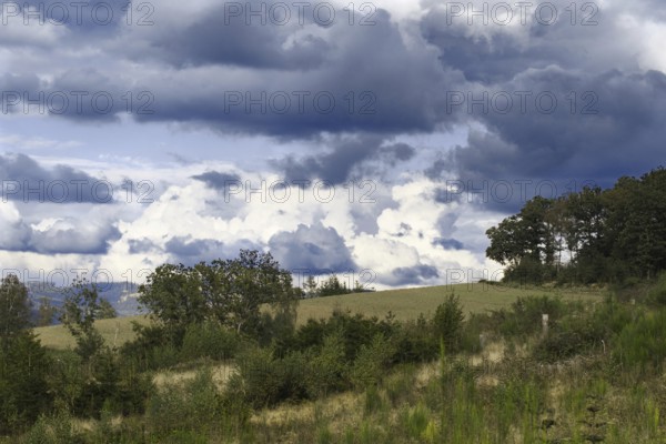 Cloudy sky over green fields and trees in a quiet landscape, Kreuztal, Siegerland