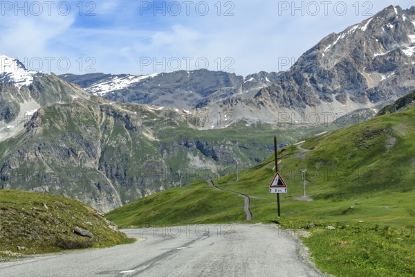Northern pass road Mountain road from Col de l'Iseran Alpine pass to Val d'Isere Val-d'isere above tree line, on the right warning sign Traffic sign Rockfall over 2 two kilometres, Col de l'Iseran, departmental road D902, Route des Grandes Alpes, Département Savoie, Region Auvergne-Rhône-Alpes, Graian Alps, France