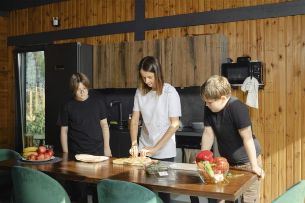 A single mother cooks healthy meals in bright kitchen while her two children watch the process