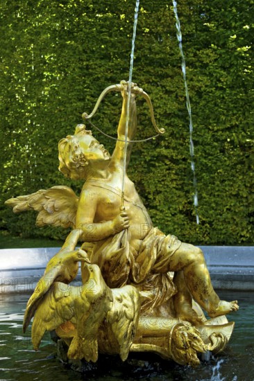Fountain figure of Cupid, god of love, in gold with bow and arrow, Rococo style, east parterre, park of Linderhof Castle, UNESCO World Heritage Site, Ettal, Unterammergau, Garmisch-Partenkirchen, Upper Bavaria, Bavaria, Germany