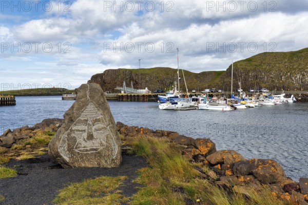 Face, engraved in a rock, boats in the harbour, rocky coastal landscape, Stykkisholmur, Snæfellsnes, Snaefellsnes, West Iceland, Iceland