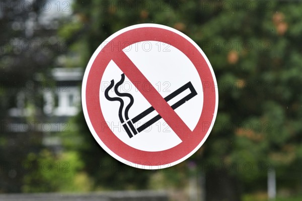 Red round 'No smoking' sign on glass wall