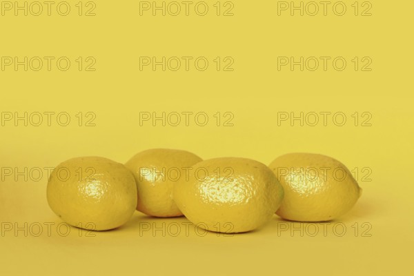 Lemon fruits on yellow background with copy space