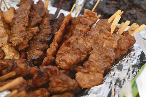 Grilled pork barbecue at Thai street food festival. Traditional Thai skewers being served at outdoor market